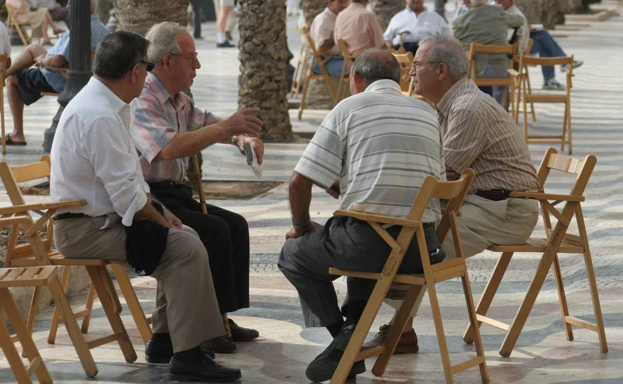 Personas mayores conversando sentadas en una plaza