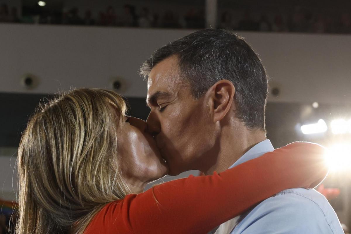 Pedro Sánchez y Begoña Gómez se besan y abrazan.