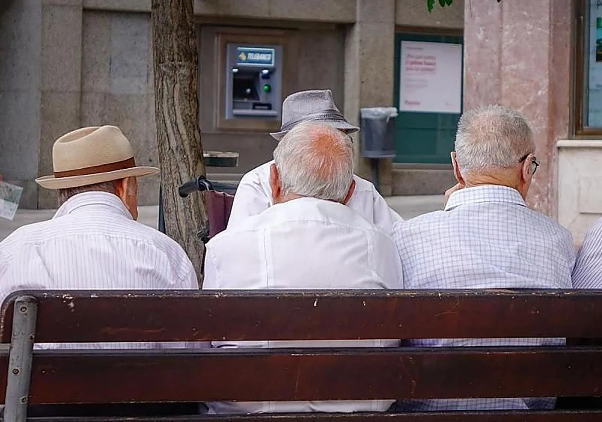 Personas mayores sentadas de espaldas en un banco